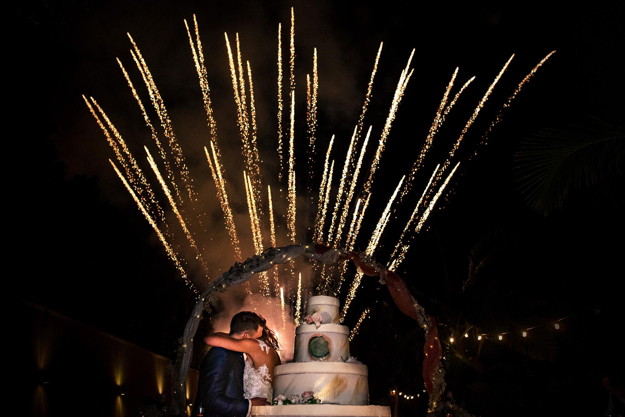 Foto degli sposi con la torta del matrimonio ed i fuochi d'artificio ad Imperia.