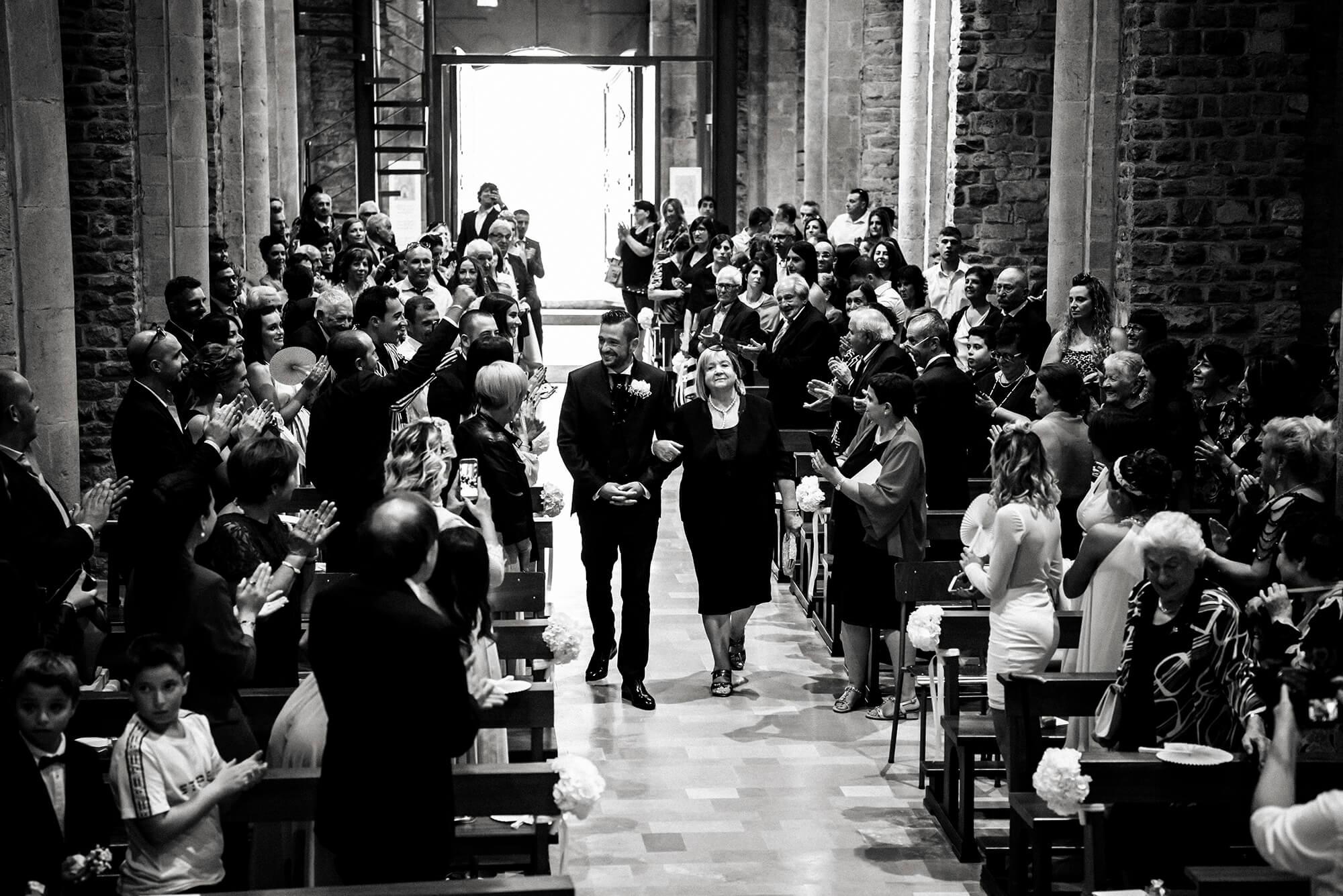Come fotografo di matrimonio capitiamo spesso in giro per tutta la Liguria, qui siamo in una chiesa di Ventimiglia, la foto ritrae lo sposo e la mamma che entrano verso l'altare.