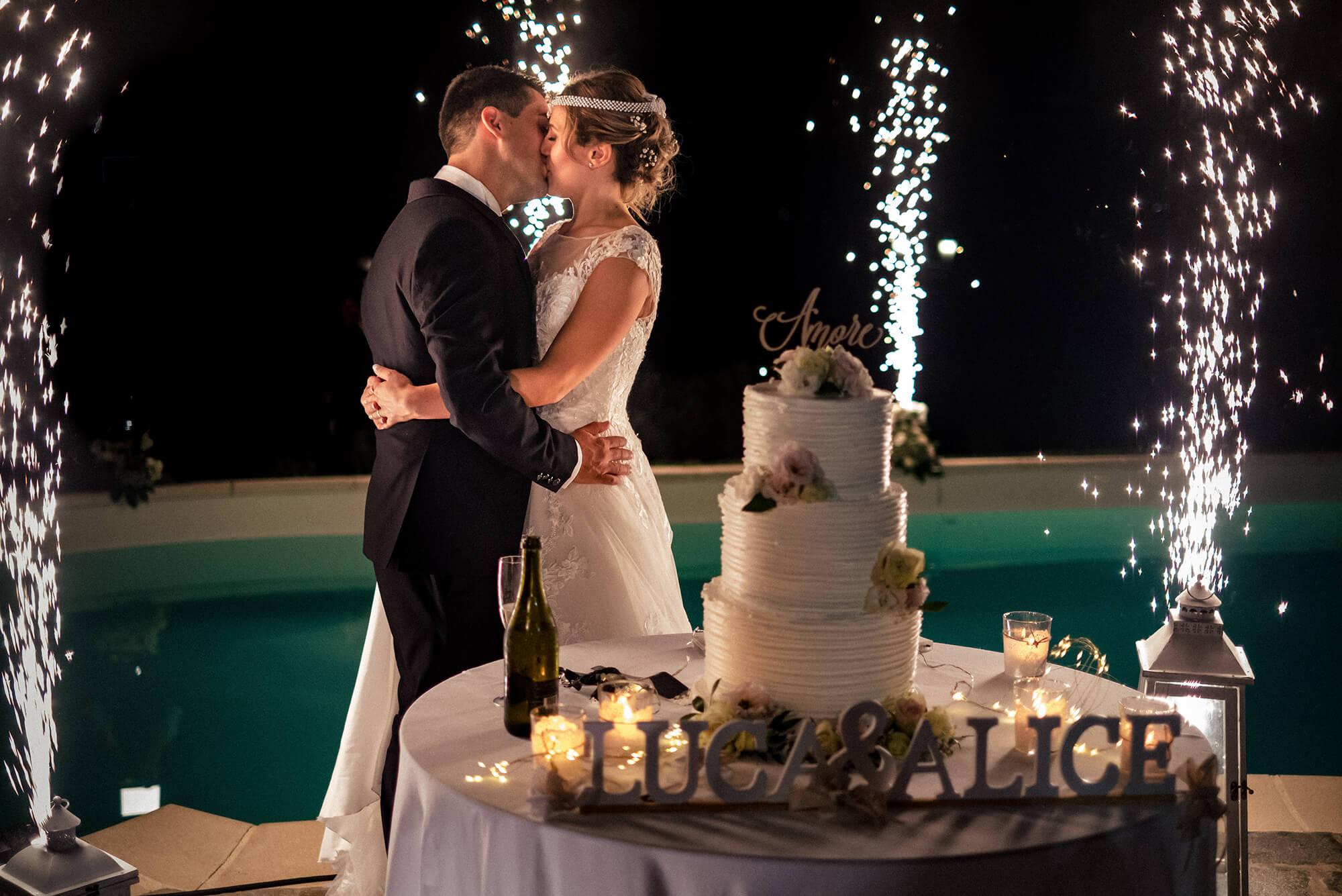 Foto del bacio degli sposi con torta e sparkle a Ca du Nonu a Vallecrosia, matrimonio in provincia di Imperia.